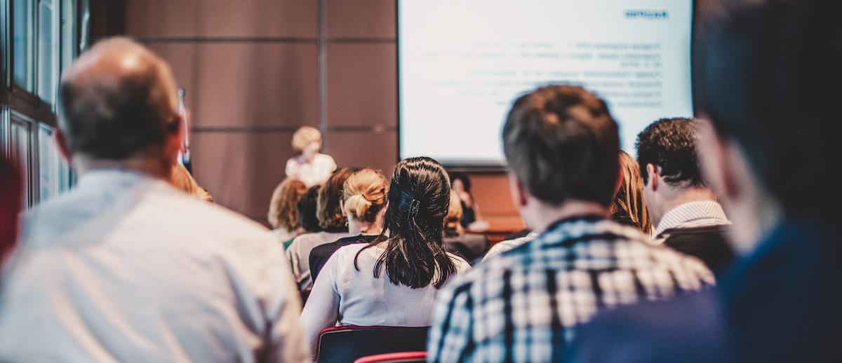 People sitting in a class photographed from behind.