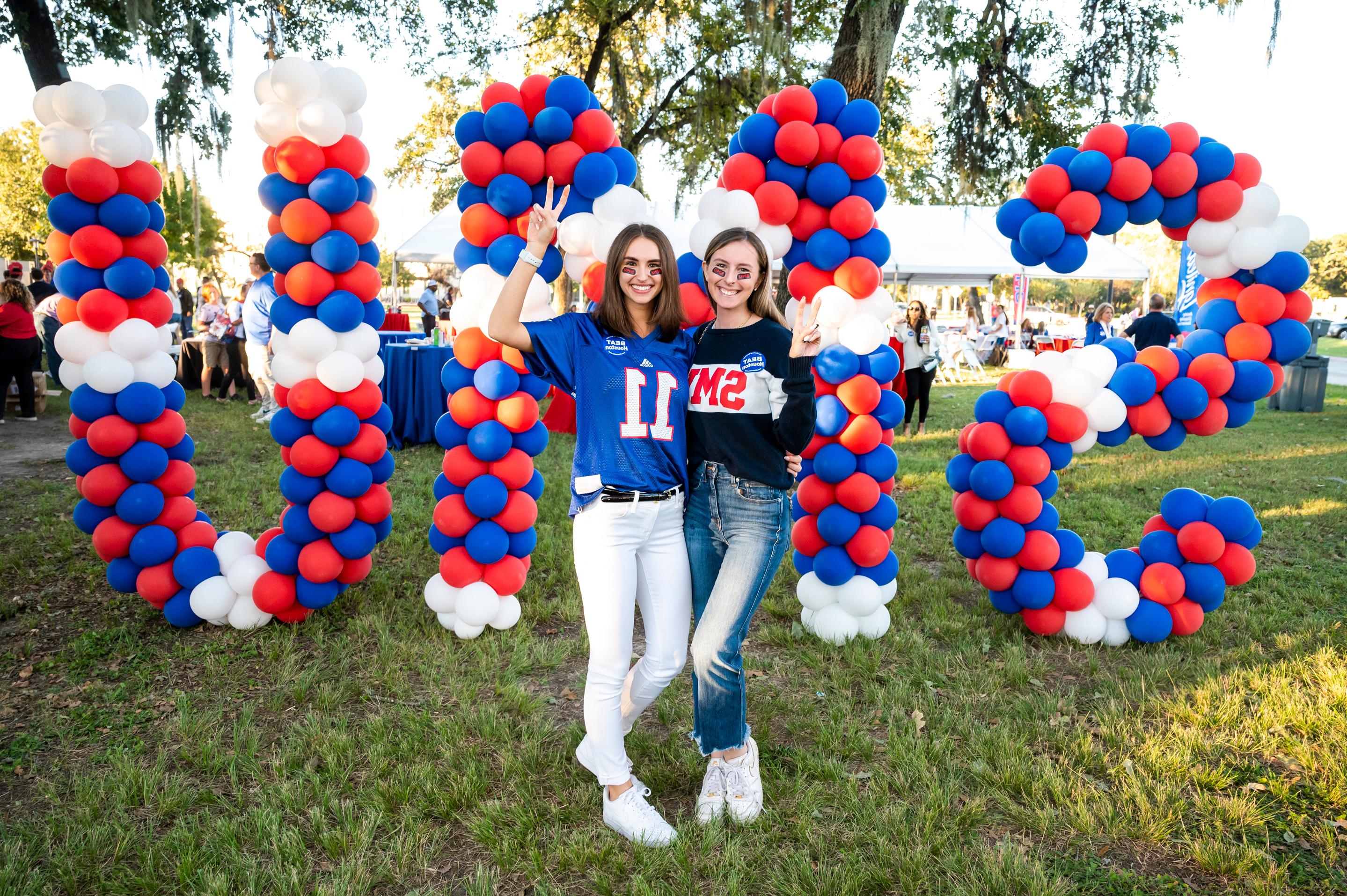 People posing in front of baloons