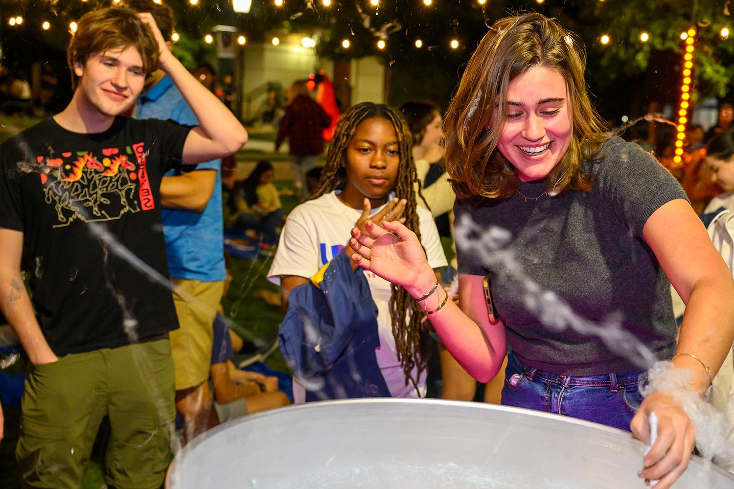 Students gathered around a large cooking pot. 